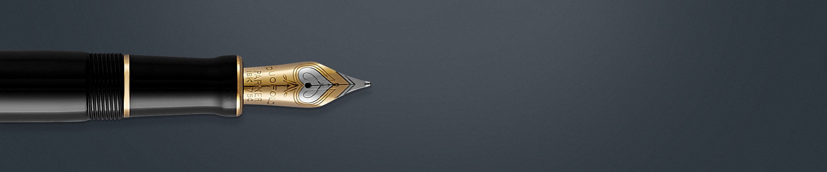 Closeup of an engraved nib on a fountain pen with gold trim.