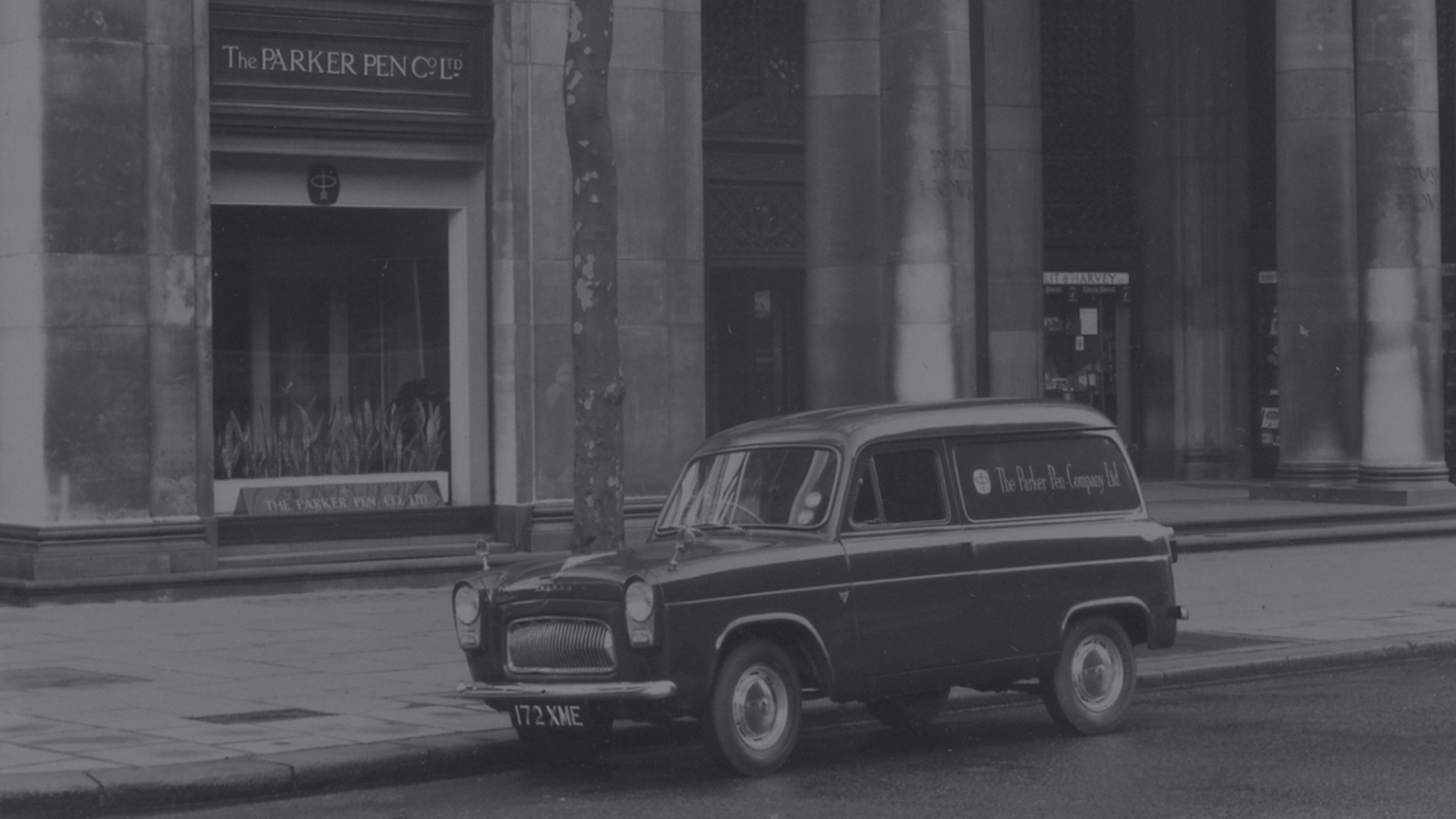 A vintage photograph of a car parked on a street.